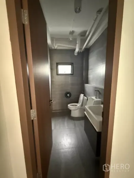 办公空间 出租在Bang Rak, Bangkok - 办公室内的卫生间，含坐便器、小便器与洗手台。