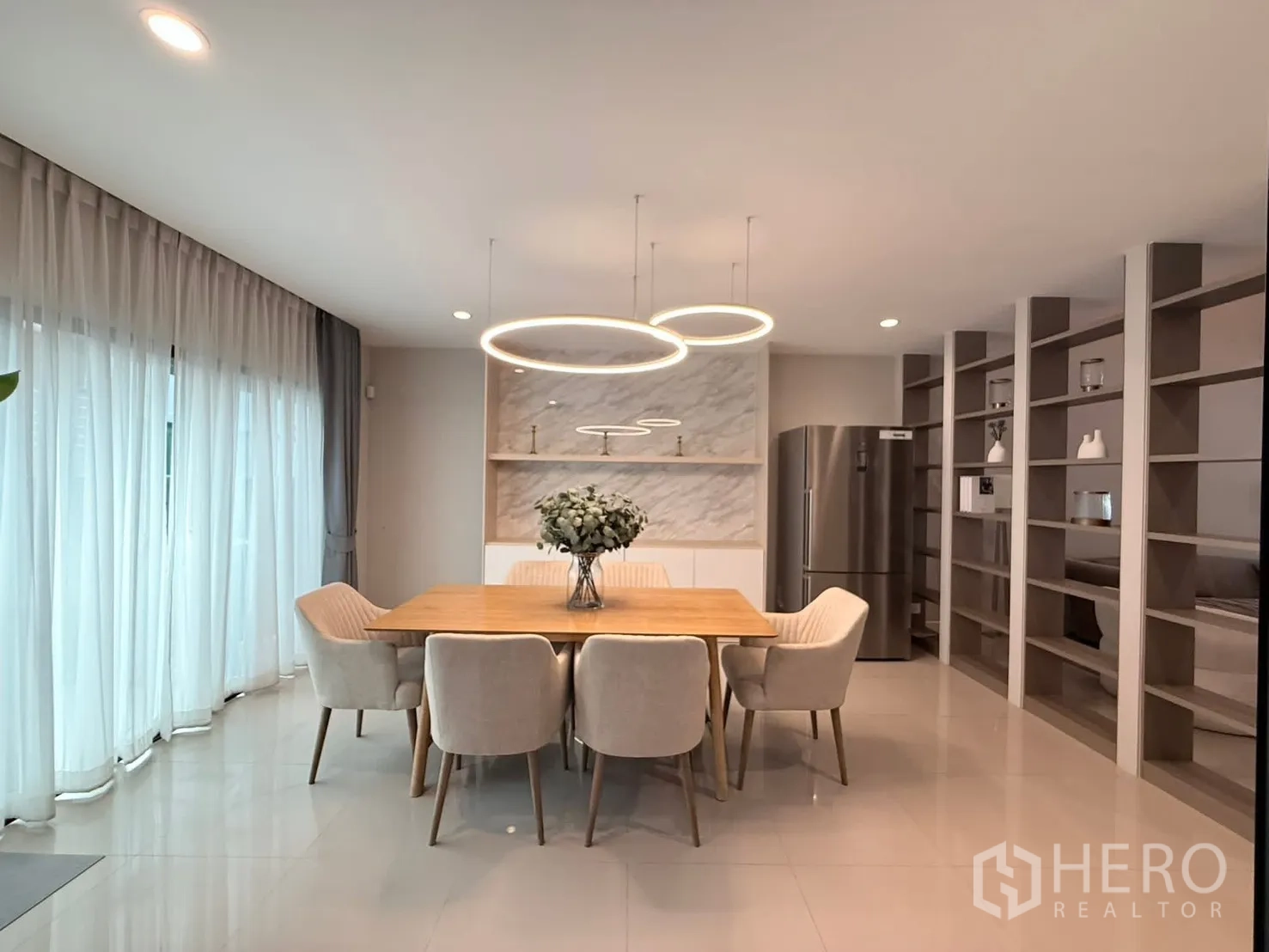 Townhouse for rent in Saphan Sung, Bangkok - Dining room with large windows, ring lights and a stainless fridge.