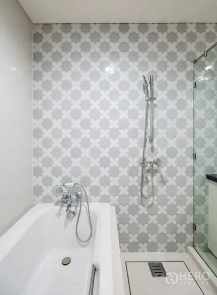 คอนโด ขาย - ภาพใกล้อ่างอาบน้ำและฝักบัวมือจับกับผนังกระเบื้องลาย