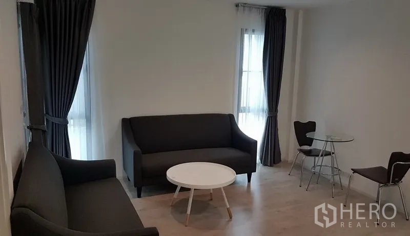 独立式住宅 出租在Prawet, Bangkok - 第二起居区，双人沙发与圆形茶几，临高窗帘。