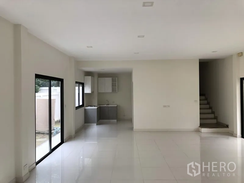 Townhouse for rent or sale in Saphan Sung, Bangkok - Spacious living–dining zone leading to a compact built-in kitchen and backyard access.