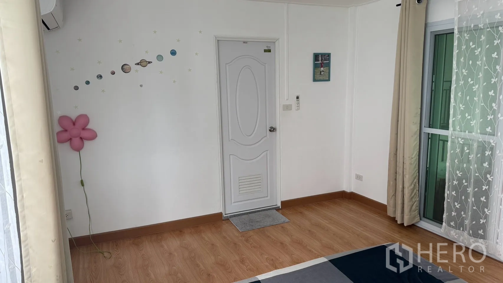 Detached House for rent in Saphan Sung, Bangkok - Bedroom wall with door, sliding balcony door and curtains, and decorative wall details.