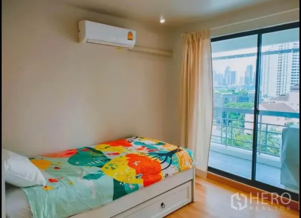 คอนโด ขายในWatthana, Bangkok - ห้องนอนสว่าง เตียงเดี่ยว ประตูกระจกเลื่อนไปยังระเบียงวิวเมือง