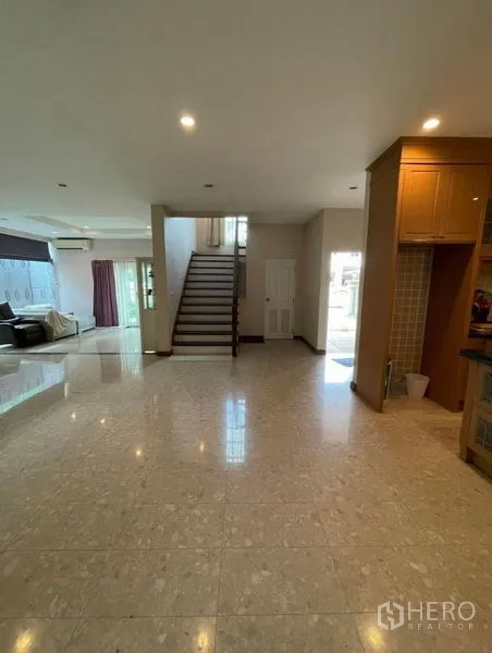 独立式住宅 出租 - 宽敞的一层开放式空间，亮面地砖与中央楼梯，自然采光充足。