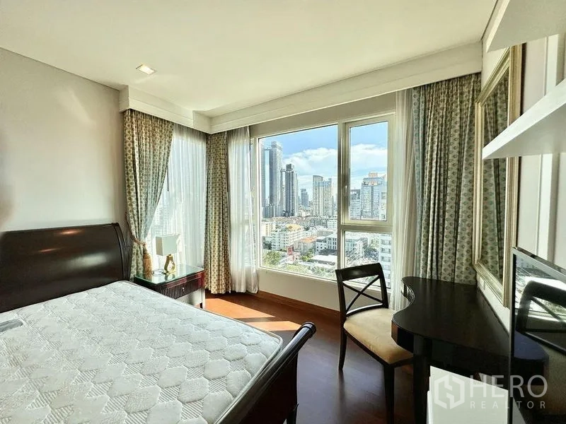 公寓 出租在Watthana, Bangkok - 转角卧室，大窗眺望曼谷天际线，配书桌与窗帘。