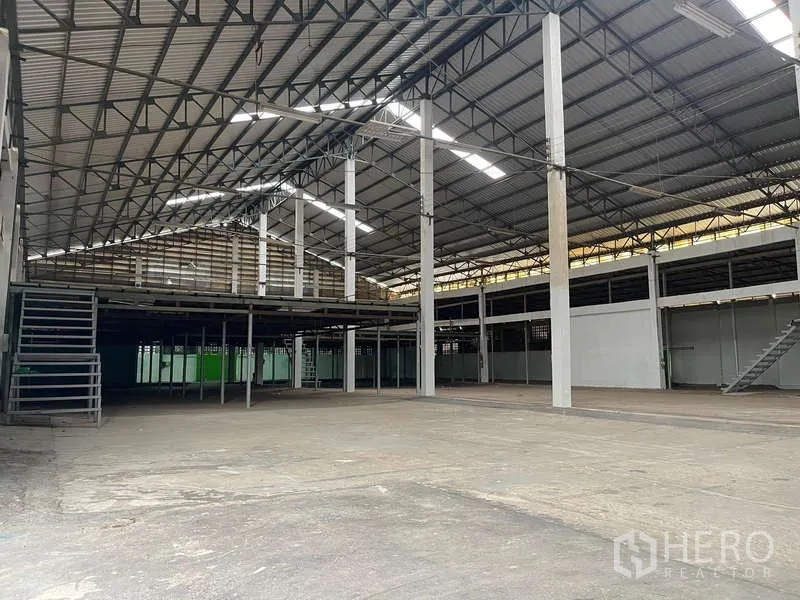 Warehouse for rent in Nong Khaem, Bangkok - Spacious warehouse interior with high steel truss roof, skylights and mezzanine platforms.