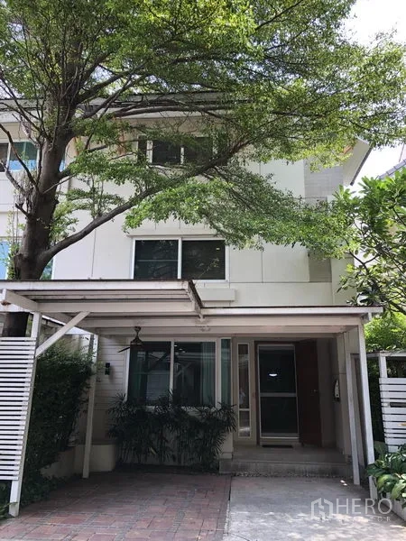 Detached House for rent in Watthana, Bangkok - Modern detached house exterior with a covered carport beneath a mature tree.
