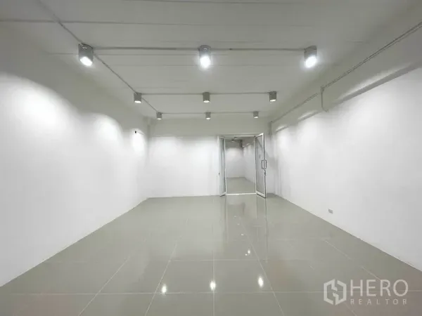 办公空间 出租在Khlong Toei, Bangkok - 明亮的开间办公室，白墙、亮面地砖与天花射灯，通向玻璃门。