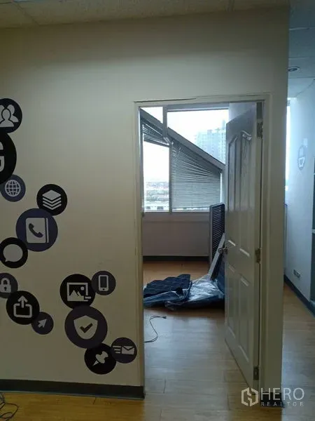 Office Space for rent - Doorway to a light-filled office room with blinds, skyline views, wall decals and laminate wood flooring.