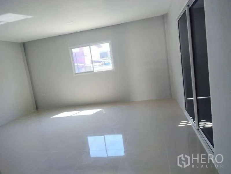Warehouse for rent in Pathum Thani - Open office space with sliding glass doors, white walls and glossy tile flooring.