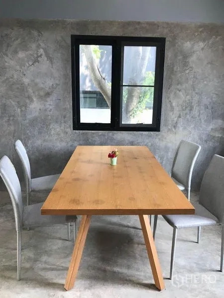 Office Space for rent in Bang Kapi, Bangkok - Small meeting area with wooden table and four chairs against a gray wall and window.
