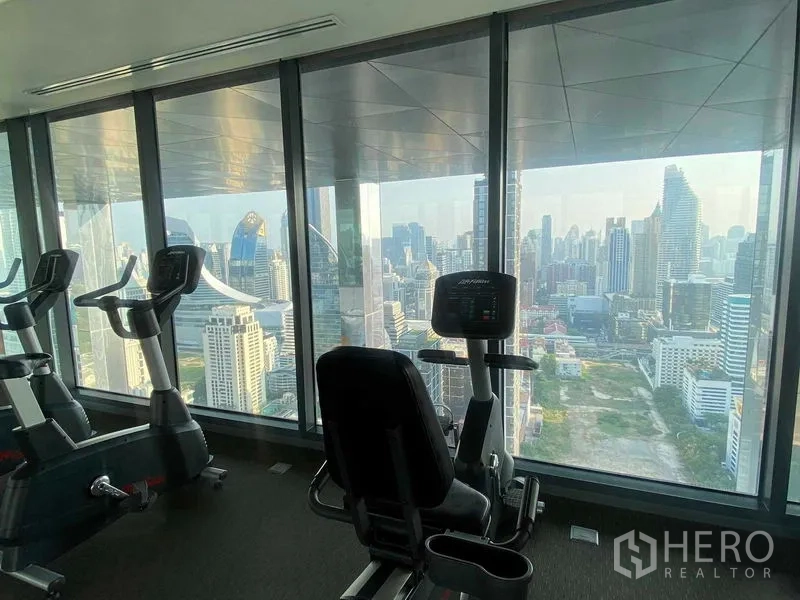 Condominium for rent or sale in Ratchathewi, Bangkok - Fitness center with cardio machines facing wide skyline views.