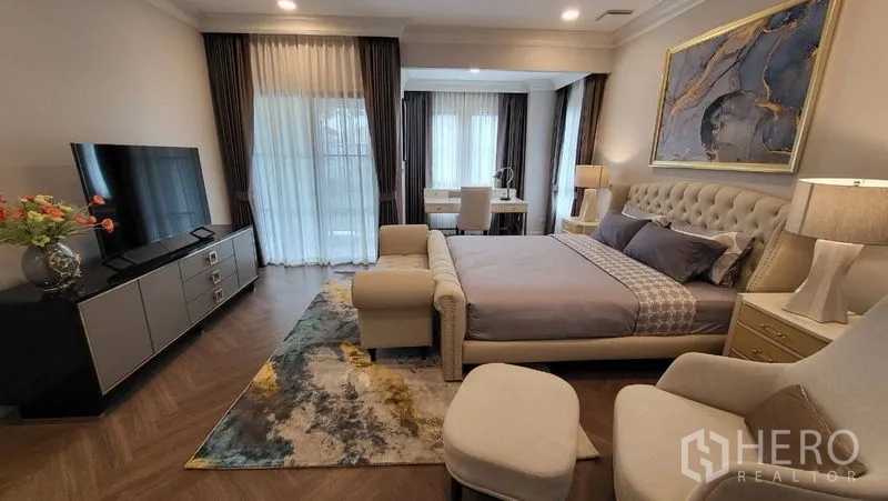 Detached House for rent or sale in Saphan Sung, Bangkok - Master suite with TV console, balcony doors, seating area and study nook.