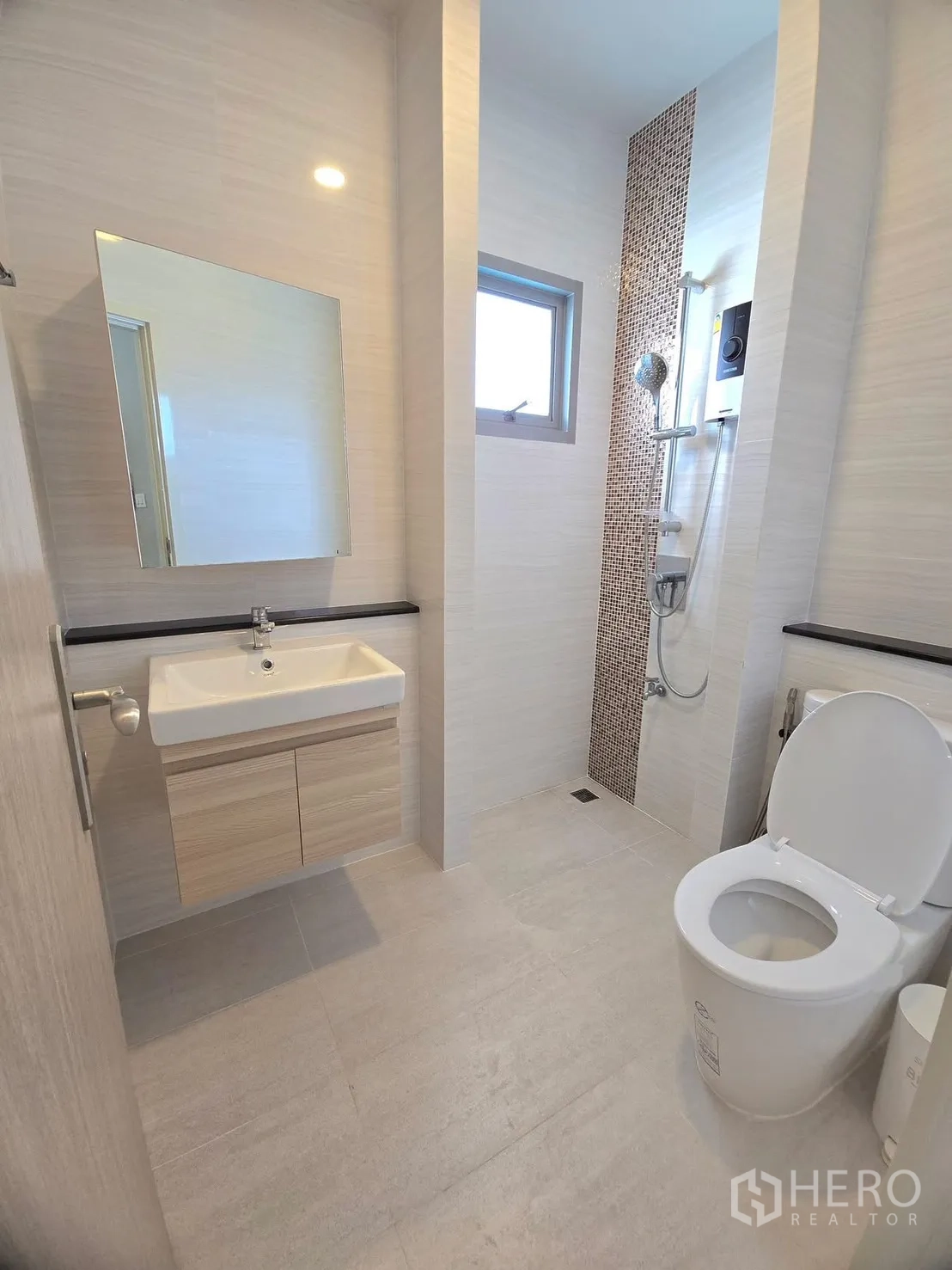 Detached House for rent in Lat Krabang, Bangkok - Bathroom with vanity, toilet and open shower zone with mosaic accent strip.