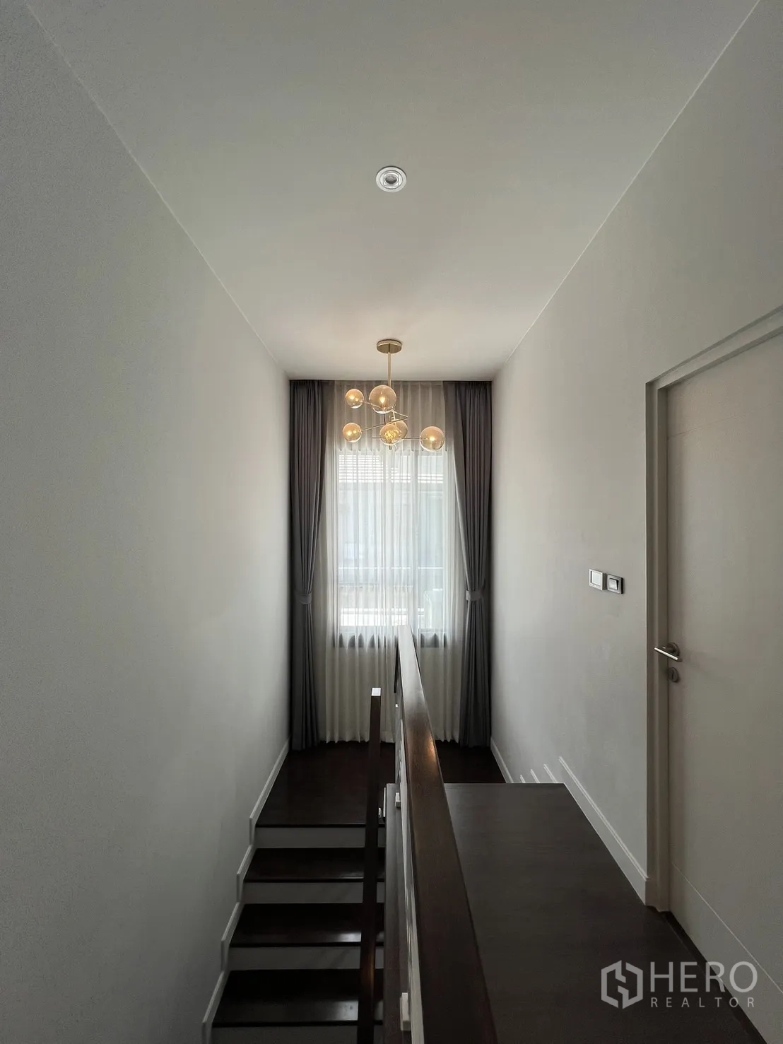 Detached House for rent or sale in Bang Kapi, Bangkok - Stair landing with pendant chandelier and soft natural light.