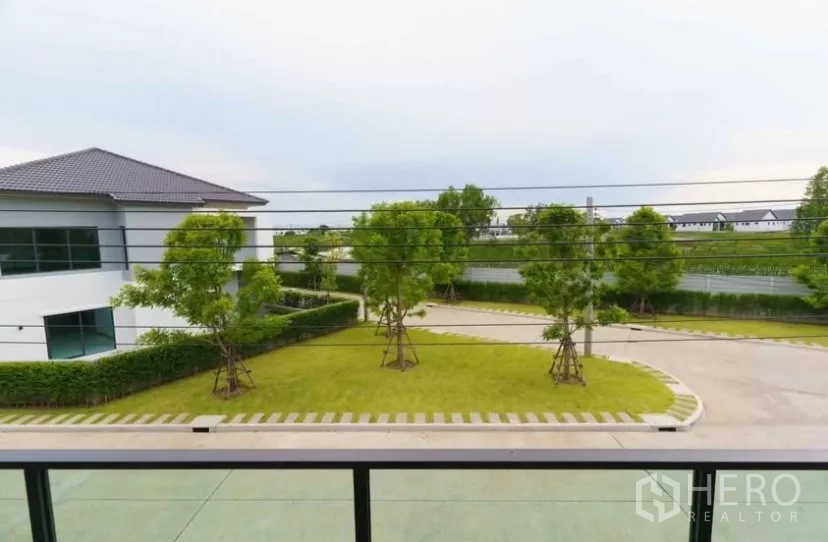 Detached House for rent or sale in Bang Phli, Samut Prakan - Balcony view over landscaped community road, lawn and trees.