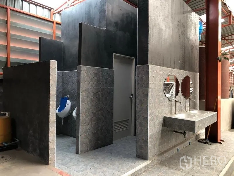 Warehouse for rent in Samut Prakan - On-site restroom block with sinks, urinals and tiled partitions for staff.