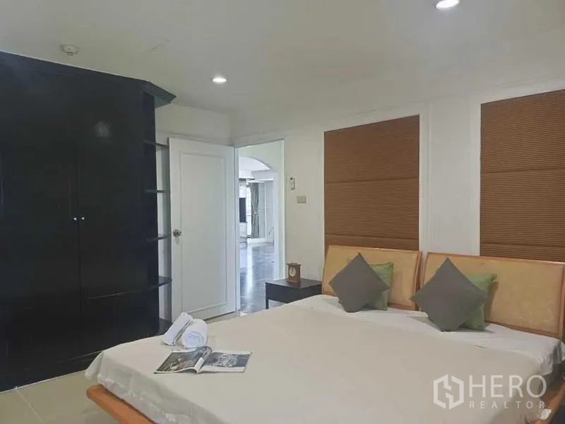 คอนโด ให้เช่าในWatthana, Bangkok - ห้องนอนอบอุ่น เตียงควีน ผนังตกแต่ง และตู้เสื้อผ้าสีดำเงา