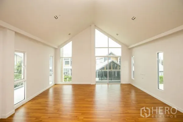 บ้าน ให้เช่าหรือขายในLam Luk Ka, Pathum Thani - ห้องนั่งเล่นมีหน้าต่างทรงจั่วและกระจกบานใหญ่รับวิวโครงการ