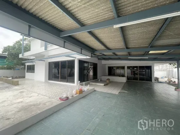 带办公室的家 出租在Din Daeng, Bangkok - 带钢结构顶棚的宽敞露台与停车区，滑动玻璃门通往一层室内。