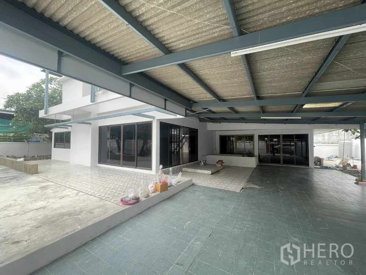 带办公室的家 出租在Din Daeng, Bangkok - 带钢结构顶棚的宽敞露台与停车区，滑动玻璃门通往一层室内。