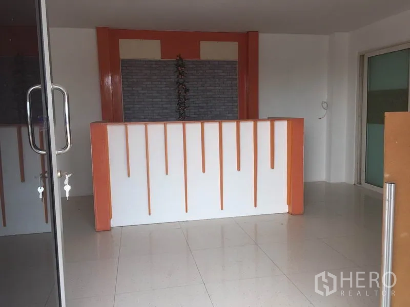 โรงงาน ให้เช่าในLam Luk Ka, Pathum Thani - โถงต้อนรับชั้นล่าง พื้นกระเบื้อง เคาน์เตอร์สีส้มขาว หลังประตูกระจก