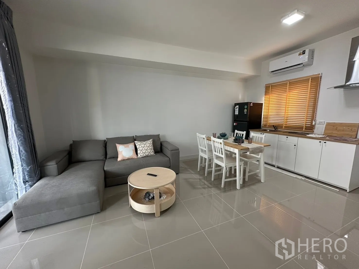 ทาวน์เฮาส์ for rent in Bang Phli, Samut Prakan - ห้องนั่งเล่นมุมกว้าง โซฟาแอล โต๊ะกลาง และโซนทานข้าว พื้นกระเบื้องเงา