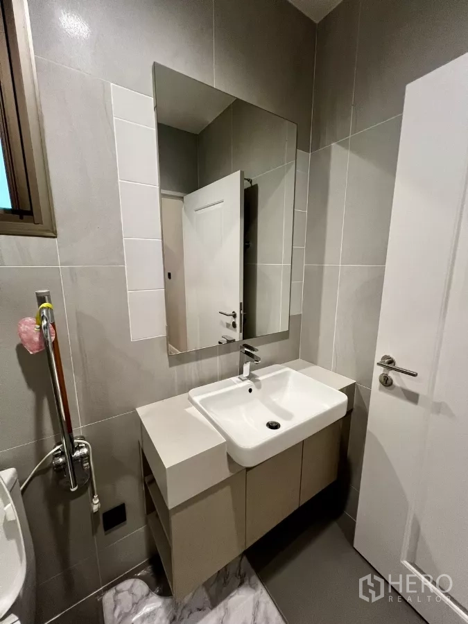 Detached House for rent or sale in Prawet, Bangkok - Compact bathroom with square basin, wall mirror and neutral tiles.