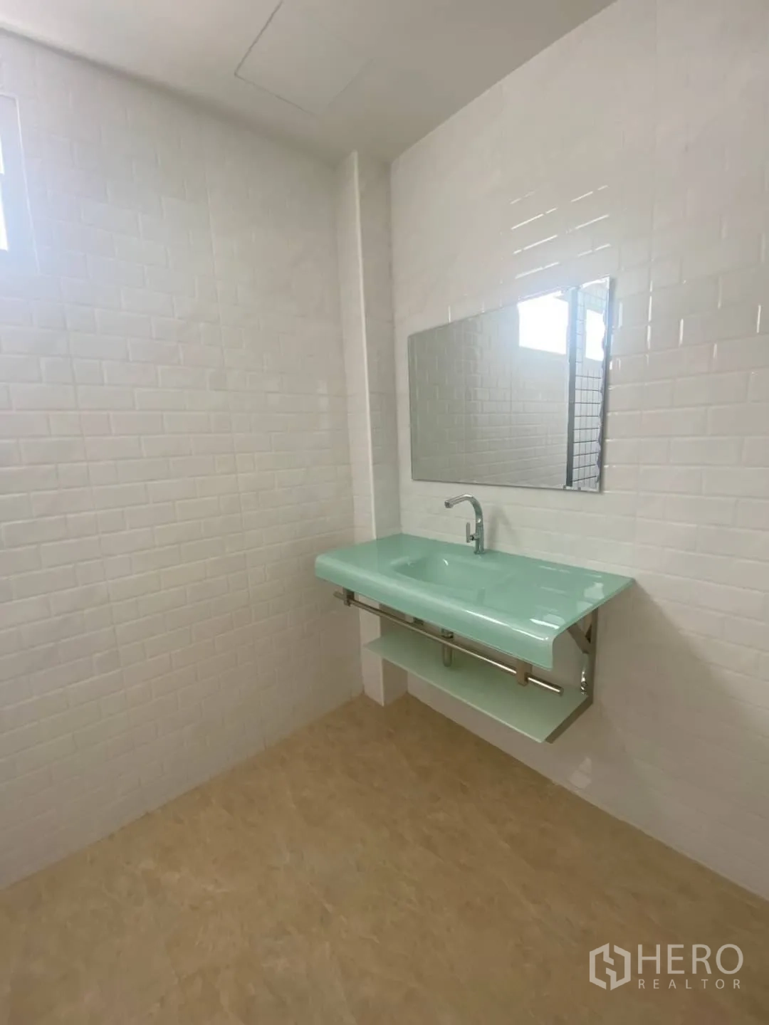 Home Office for sale - Mint glass vanity and mirror set against clean white subway tiles.