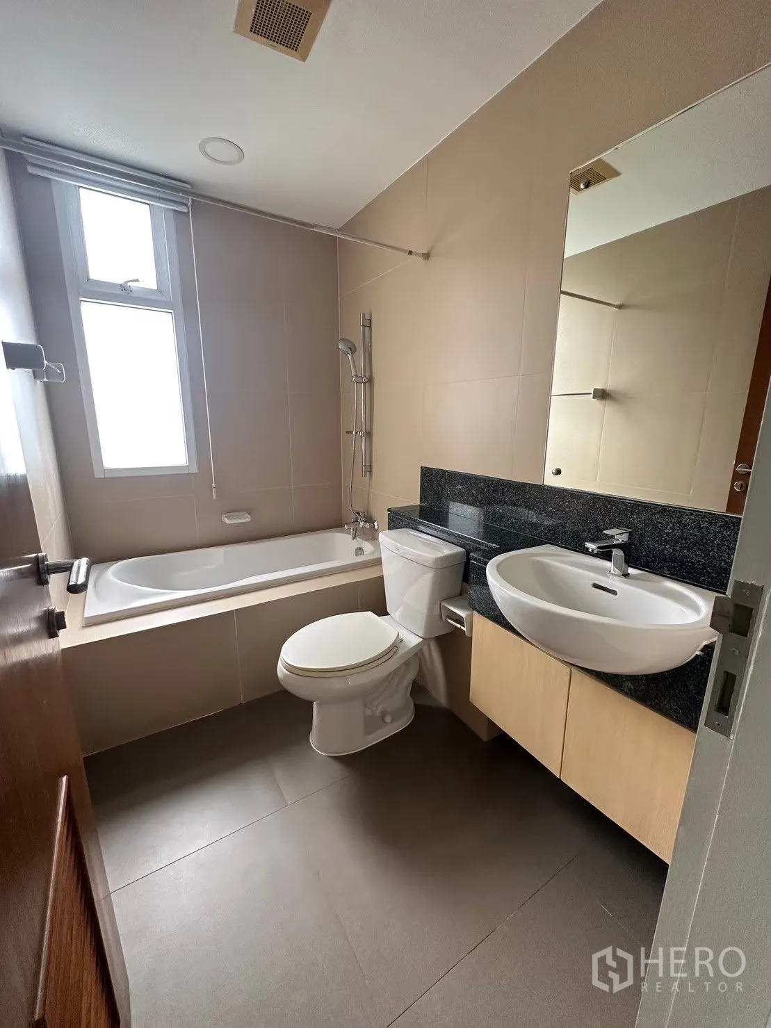 公寓 出租在Watthana, Bangkok - 浴室配浴缸、窗户、坐便与石面台盆