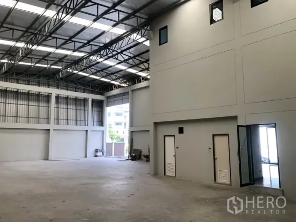 Factory for rent or sale in Bang Bua Thong, Nonthaburi - Spacious production hall with internal office rooms and large access opening.