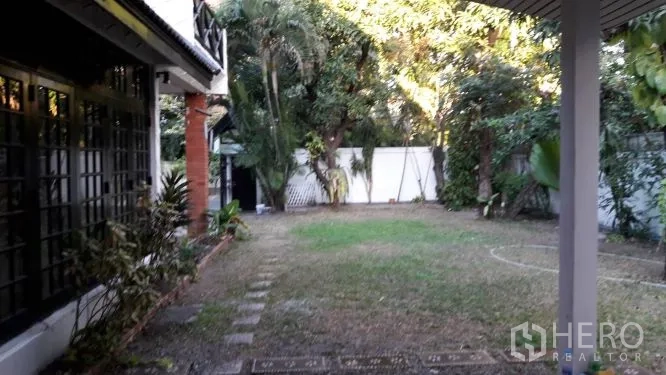 บ้าน ให้เช่าในYan Nawa, Bangkok - สนามหญ้าส่วนตัวขนาดใหญ่ รายล้อมด้วยต้นไม้และกำแพงรั้วข้างบ้าน