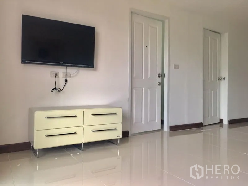 คอนโด ให้เช่าในKhlong Toei, Bangkok - ผนังทีวีแบบติดตั้งพร้อมตู้ลิ้นชัก พื้นกระเบื้องเงา และประตูสีขาว