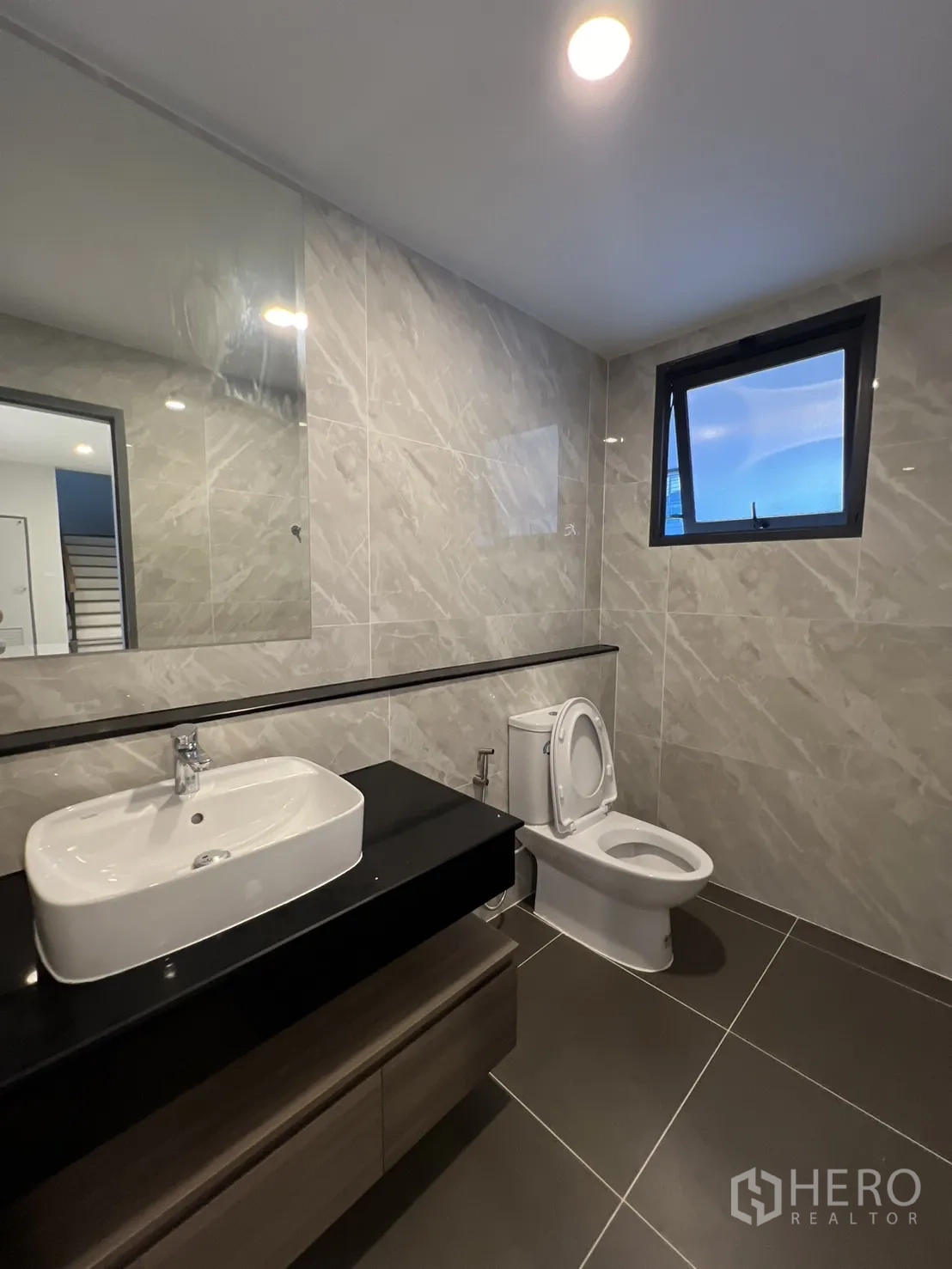 Detached House for rent or sale in Bang Phli, Samut Prakan - Ground-floor bathroom with gray wall tiles, vanity, toilet and window.