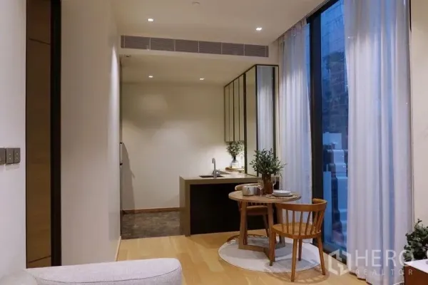 公寓 出租在Pathum Wan, Bangkok - 开放式餐厨空间，木地板与高窗，圆桌双座