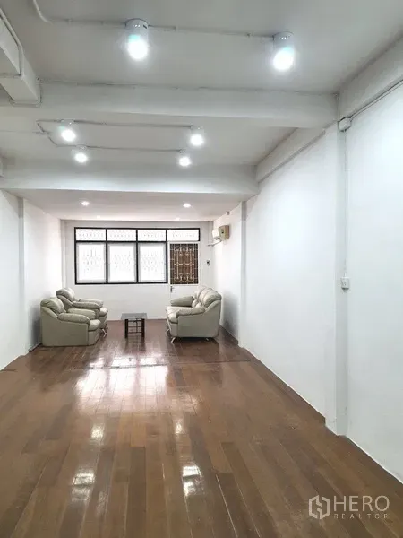 อาคารพาณิชย์ ให้เช่าในPhra Khanong, Bangkok - ห้องชั้นบนขนาดใหญ่ พื้นไม้ มีโซฟาและหน้าต่างบานกว้างรับแสงธรรมชาติ
