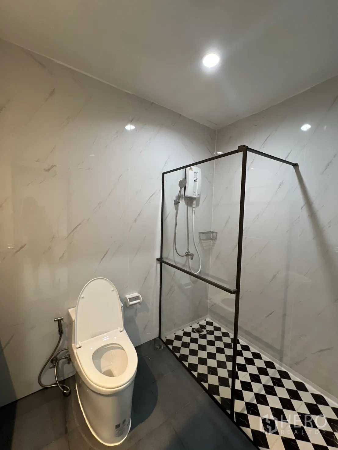 ทาวน์เฮาส์ for rent in Watthana, Bangkok - ห้องน้ำพร้อมตู้กระจกอาบน้ำและพื้นลายตารางขาวดำ ข้างโถสุขภัณฑ์