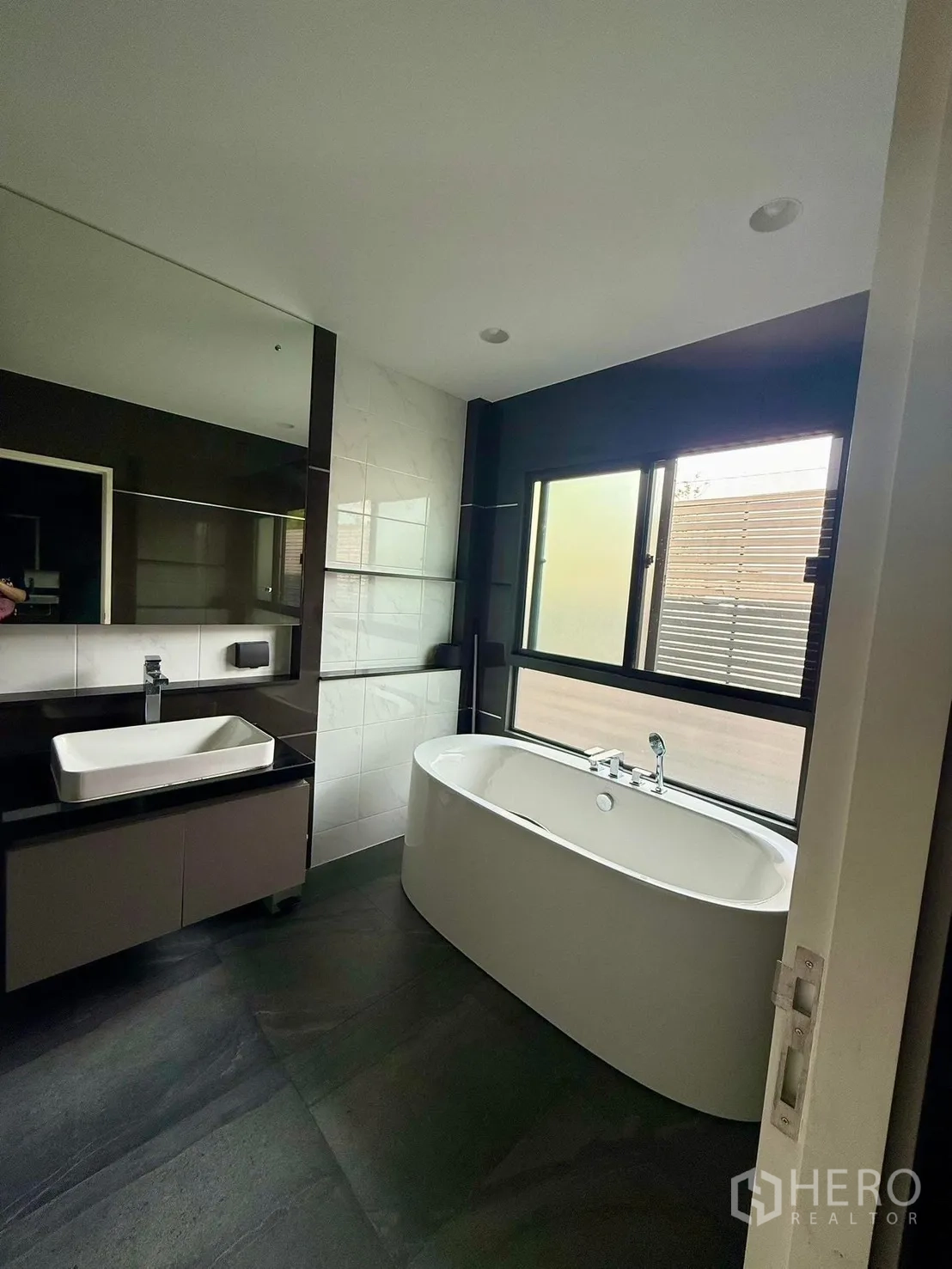 Detached House for rent in Bang Kapi, Bangkok - Bathroom featuring freestanding bathtub, large mirror and window.
