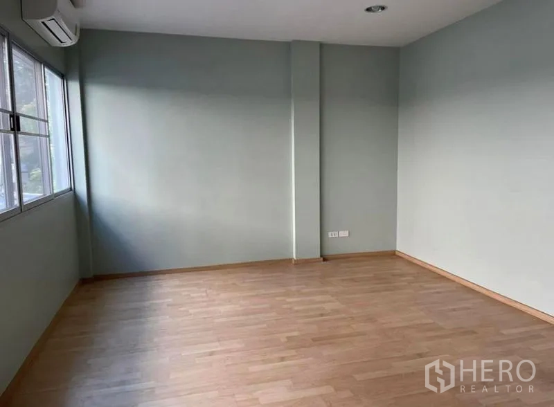 ทาวน์เฮาส์ ให้เช่าในSuan Luang, Bangkok - ห้องชั้นบนขนาดใหญ่ พื้นไม้สีอ่อน ผนังเขียวอ่อน หน้าต่างกว้างและแอร์ผนัง