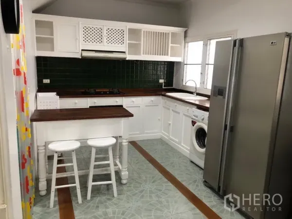 ทาวน์เฮาส์ ให้เช่าในMueang Samut Prakan, Samut Prakan - ครัวปิดโทนขาว เคาน์เตอร์ไม้ กระเบื้องผนังสีเขียว เกาะกลางพร้อมสตูล ตู้เย็นและเครื่องซักผ้า