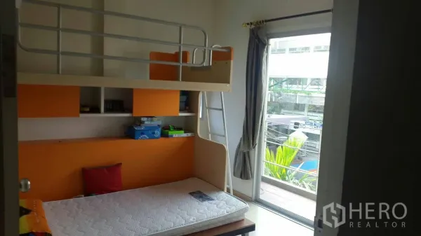 联排别墅 出租在Suan Luang, Bangkok - 儿童卧室配高低床与橙色收纳，并可通往小阳台。