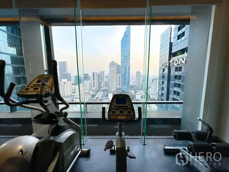 公寓 出租在Bang Rak, Bangkok - 空中健身房配有心肺训练器材，正对全景城市景观，近BTS Chong Nonsi