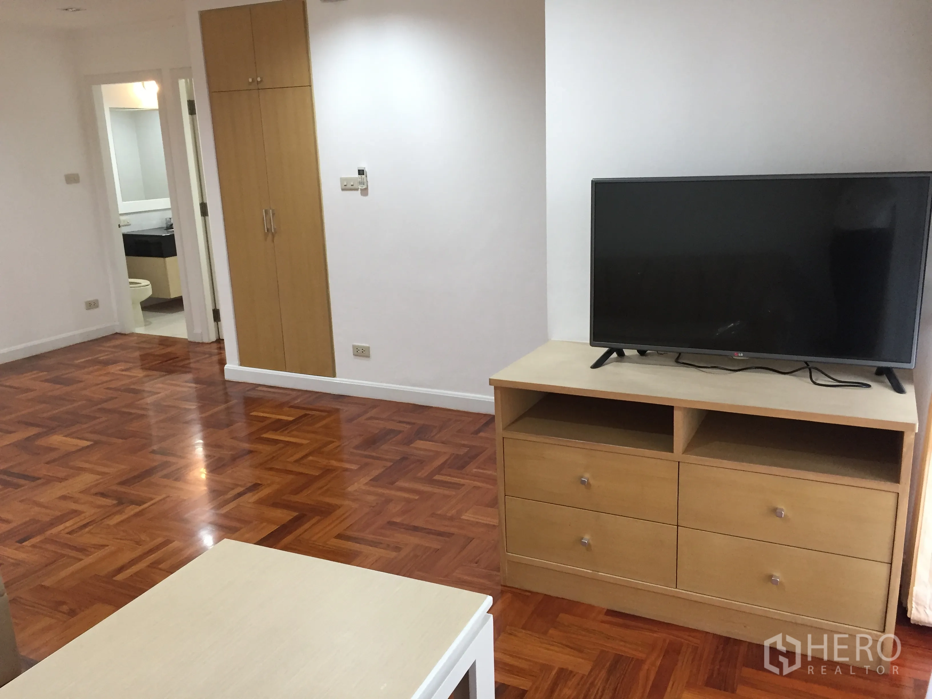 คอนโด ให้เช่าในWatthana, Bangkok - พื้นที่พักผ่อนพร้อมทีวีบนตู้ลิ้นชัก ตู้เก็บของบิวท์อิน ประตูสู่ห้องน้ำ และพื้นปาร์เกต์มันวาว