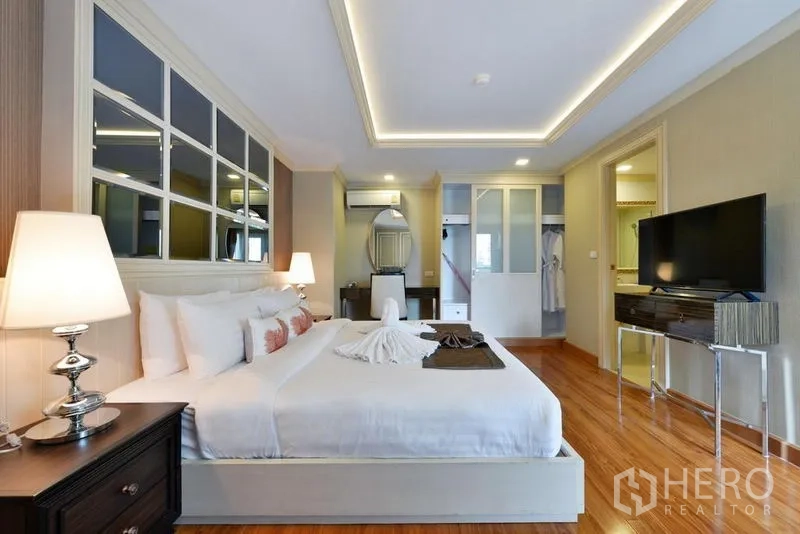 房间 出租在Khlong Toei, Bangkok - 卧室全景，特大床、开放式衣柜、床头柜与电视柜。