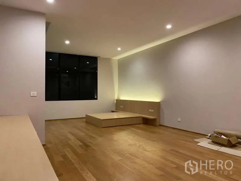 ทาวน์เฮาส์ ให้เช่าหรือขายในSaphan Sung, Bangkok - ห้องนอนใหญ่ยามค่ำ ไฟดาวน์ไลต์ เตียงยกพื้น และหน้าต่างกรอบดำ