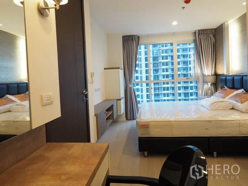 Condominium for rent in Sathon, Bangkok - Master bedroom view toward large windows and built-in TV cabinet.