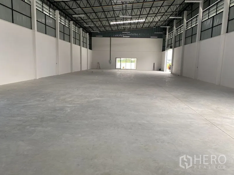 Warehouse for rent or sale in Bang Len, Nakhon Pathom - Spacious clear-span warehouse interior with high steel truss ceiling, LED lighting and polished concrete floor.