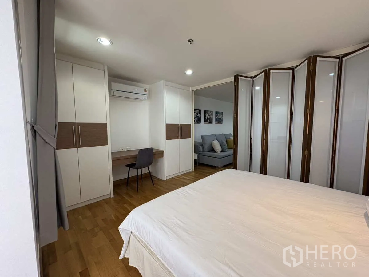 公寓 出租在Khlong Toei, Bangkok - 卧室设衣柜、书桌与折叠隔断门。