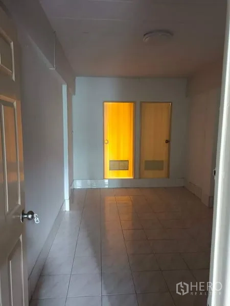 Retail Space for sale in Lam Luk Ka, Pathum Thani - Empty tiled room with two internal doors, suitable for storage or office.