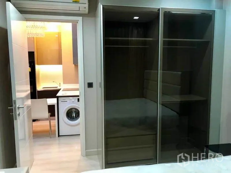 คอนโด ให้เช่าหรือขายในPhaya Thai, Bangkok - ห้องนอนตู้เสื้อผ้าบานเลื่อนกระจก มองไปเห็นครัวและเครื่องซักผ้า